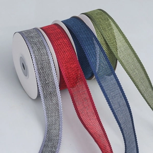 Detailed view of colorful woven ribbons in red, grey, blue and green for DIY Christmas decor