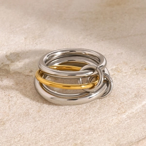 Dettaglio di anelli a fascia in acciaio inossidabile con design a incastro oro e argento