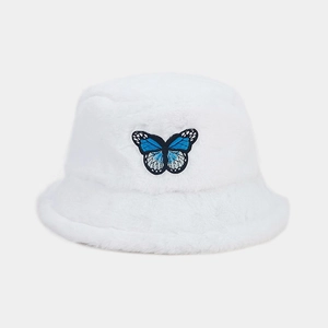 Close-up of fluffy white faux fur bucket hat with blue butterfly embroidery detail