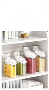 Detail of transparent kitchen storage jars with white lids, handles and measurement marks