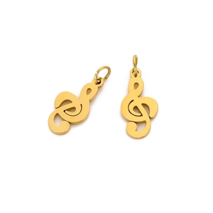 Macro detail of two golden treble clef metal pendants with smooth polished finish
