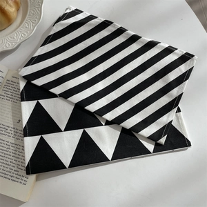 Close-up of geometric black and white placemats with diagonal stripes and triangle patterns