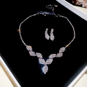 Detailed view of silver necklace and teardrop earrings set with sparkling rhinestones