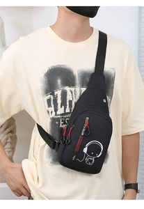 Detail of black crossbody chest bag with luminous astronaut print on male model