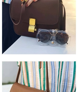 Detail view of a vintage dark brown leather shoulder bag with gold square buckle clasp