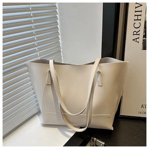 Minimalist large white tote bag in premium faux leather under soft window light