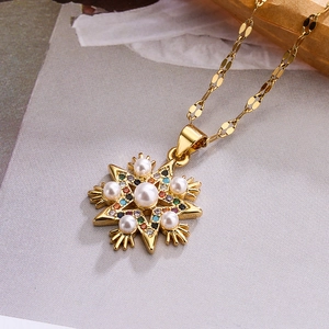 Collier flocon de neige doré avec perles blanches et zircons colorés sur papier texturé