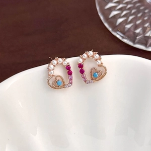 Close-up of heart stud earrings with pink zircon, blue gemstones and small white pearls