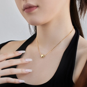 Elegant gold heart pendant necklace on S925 sterling silver chain worn by a model