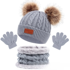Détail du bonnet en tricot gris pour enfants avec pompons et doublure polaire chaude