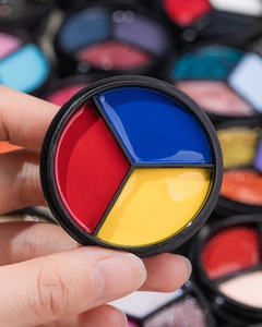 Detailed close-up of primary red, blue, and yellow solid gel polish in a round black jar