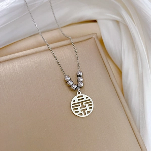Macro view of silver titanium steel necklace featuring double happiness character pendant