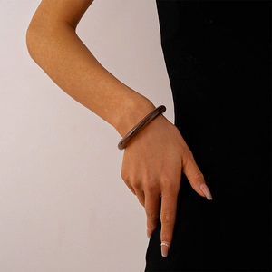 Detail of vintage acrylic cuff bracelet with brown marble texture worn on wrist