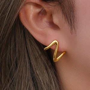 Close-up of elegant gold Z-shaped stainless steel earrings on a model's ear