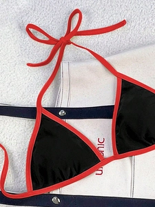 Detail of red and black color-block bikini top with adjustable halter ties and triangle cups