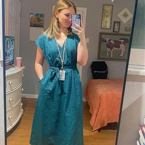 Detail of teal V-neck short sleeve midi dress with waist tie and textured fabric