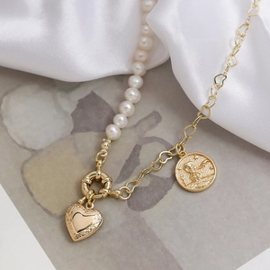 Detail of half pearl half gold heart link necklace with heart lock and coin pendant