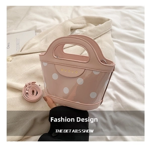 Pink polka dot handbag with transparent PVC base and gold MUDUO logo detail