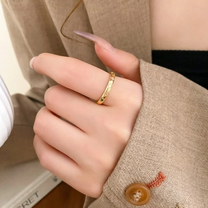 Detail of gold star engraved rings with colorful zircon inlays on person wearing suit