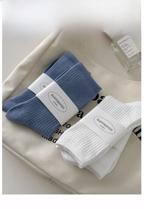 Detailed texture of blue and white ribbed cotton socks with minimalist brand packaging