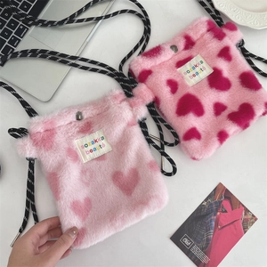 Detailed view of plush heart-pattern crossbody bags with rope straps and snap closure