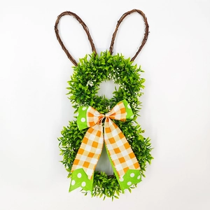 Detail of Easter rabbit wreath with green faux leaves and a plaid bow on white background