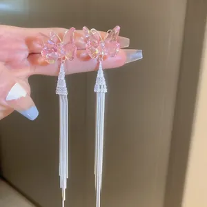 Close-up of pink butterfly long tassel earrings with sparkling rhinestones and silver fringe