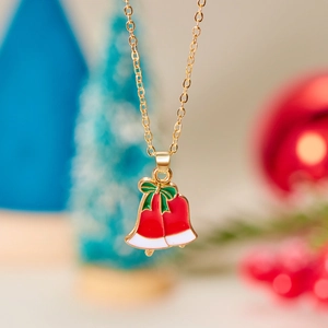 Christmas necklace with gold chain and colorful festive bells on a blurry holiday background