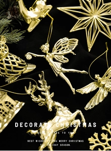 Detailed view of gold electroplated Christmas ornaments on black velvet with pine branches