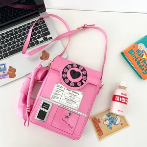 Detail of pink vintage telephone crossbody bag with retro dial and coiled handset cord