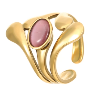 Gros plan d'une bague dorée moderne avec une pierre rose ovale et effet œil-de-chat