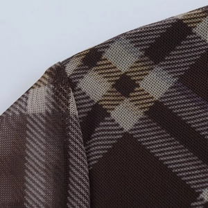 Gros plan de la couture d'épaule et de la texture en résille sur robe à carreaux