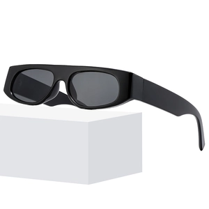Retro rectangular black thick frame sunglasses with dark lenses on a white platform