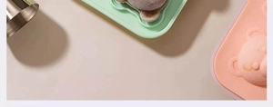 Close-up of pink and green bear-shaped silicone ice molds for creative beverage making