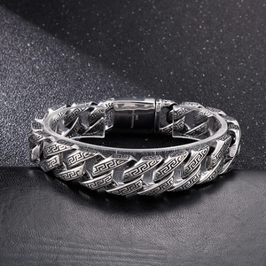 Detail of 316L stainless steel bracelet showing Greek key pattern and material engraving