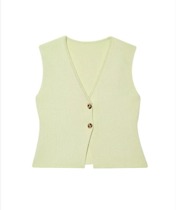 Détail d'un gilet en tricot vert clair avec col en V et boutons dorés sur fond blanc