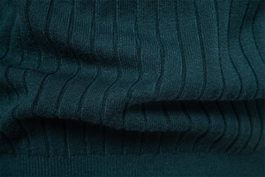 Detailed close-up of dark teal knit fabric showing premium vertical ribbed texture
