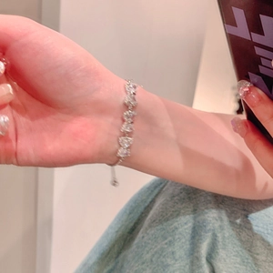 Elegant silver bow bracelet featuring sparkling zircon stones worn on the wrist