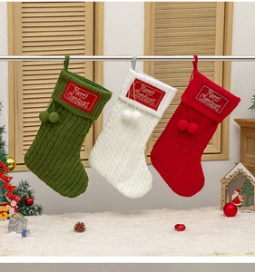 Close-up of three knitted Christmas stockings in red, green and white with pom-poms
