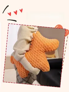 Detail of orange pony plush pillow in pineapple fleece held in a home setting