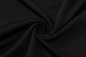Detailed macro view of black dress fabric texture showing its soft drape and quality