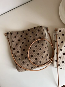 Detail of brown polka dot corduroy crossbody bag with simple wish textile label