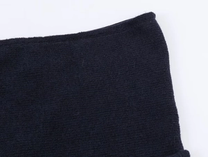 Close-up of high-quality navy blue knitted fabric texture and detailed stitching of the top