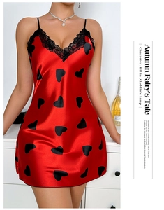 Close-up of red silk satin nightdress featuring black heart prints and V-neck lace trim