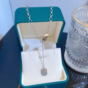 Macro shot of titanium steel chain necklace with lucky tag pendants in a jewelry box