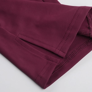 Gros plan sur la double couture et la fente latérale du combishort de sport bordeaux