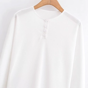 White waffle knit long sleeve henley shirt with buttons on a wooden hanger
