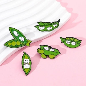 Close-up of five cute green pea pod enamel pins featuring white cat faces inside