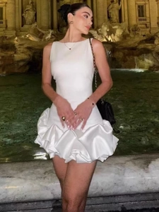 Robe blanche sans manches avec ourlet à volants et taille ajustée devant la fontaine