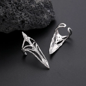 Detailed view of silver gothic claw rings with polished finish on black volcanic rock
